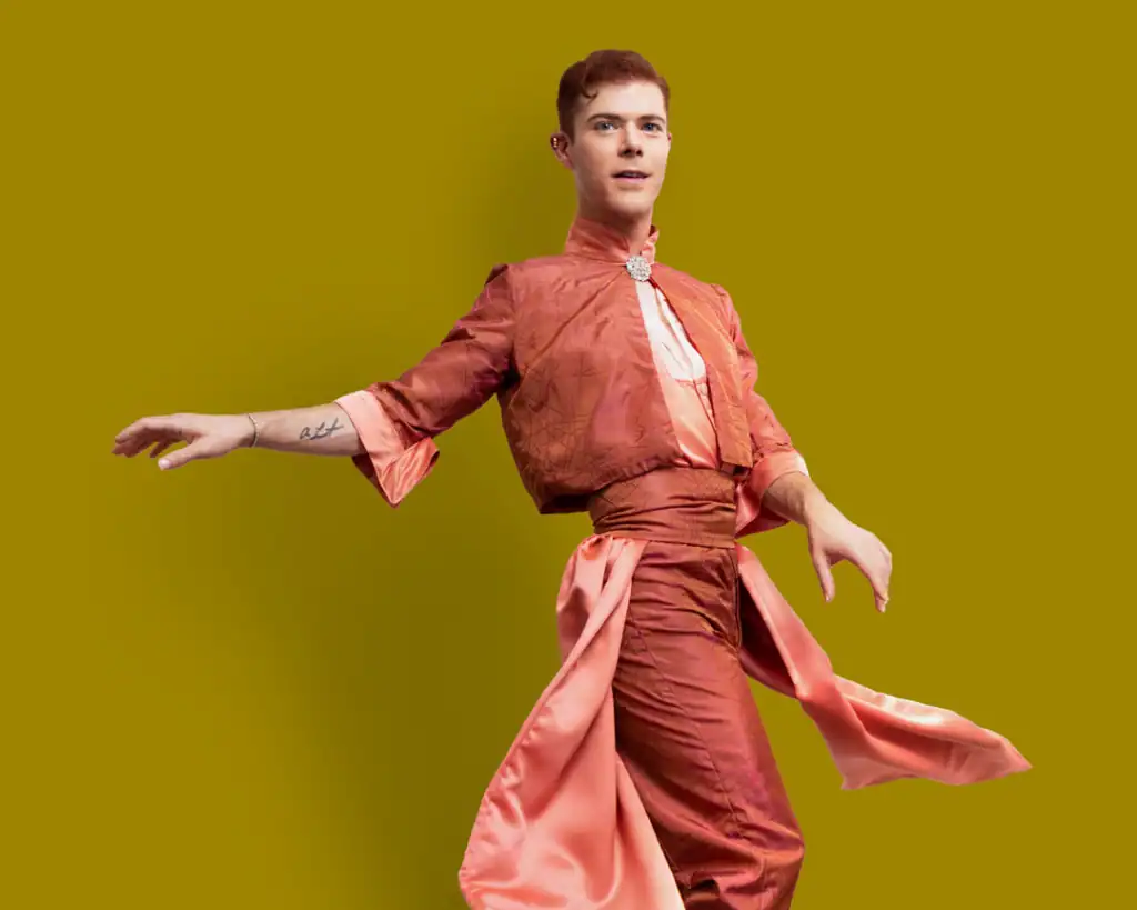 Elijah's feminine suit design in coral with draped fabrics.