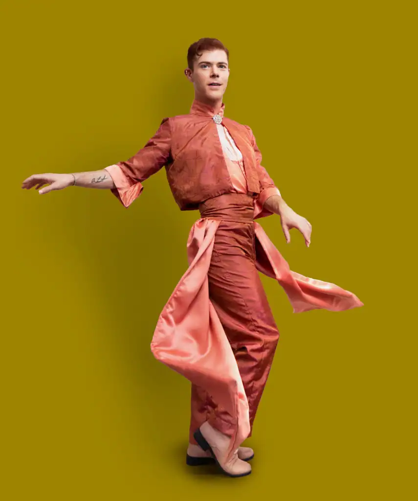 Elijah's feminine suit design in coral with draped fabrics.