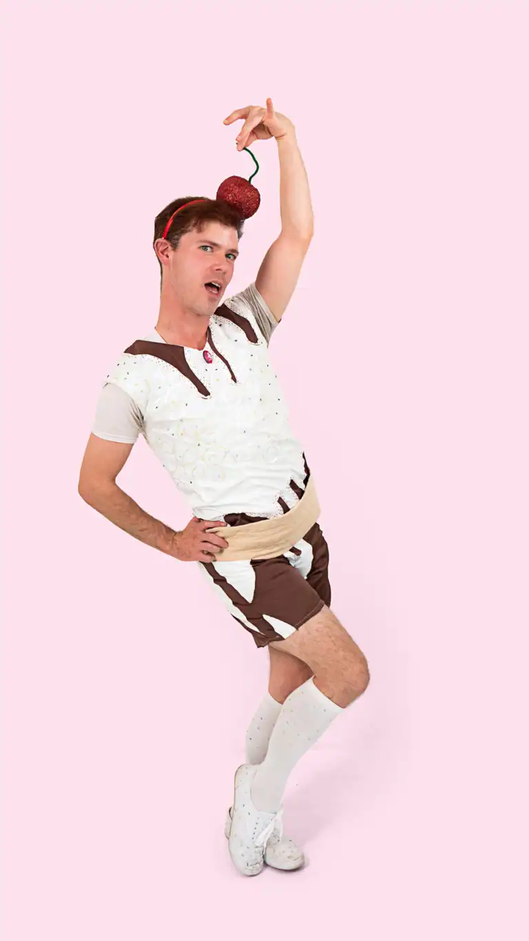 Designs Elijah in sexy pose in a Sundae costume, with a cherry on top.