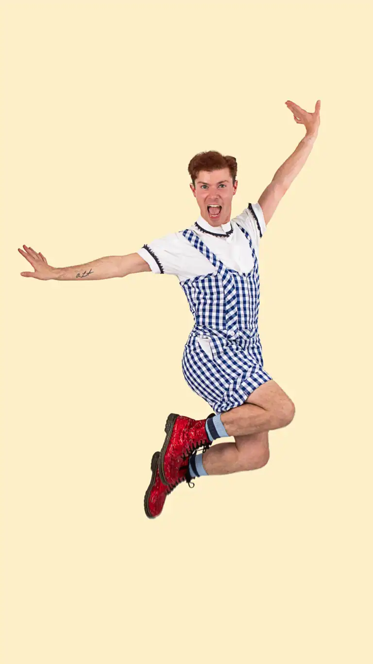 Designs Elijah's Dorothy costume, a gingham shorts jumper with pockets, detailed collar and sleeves, and sparkly red boots.