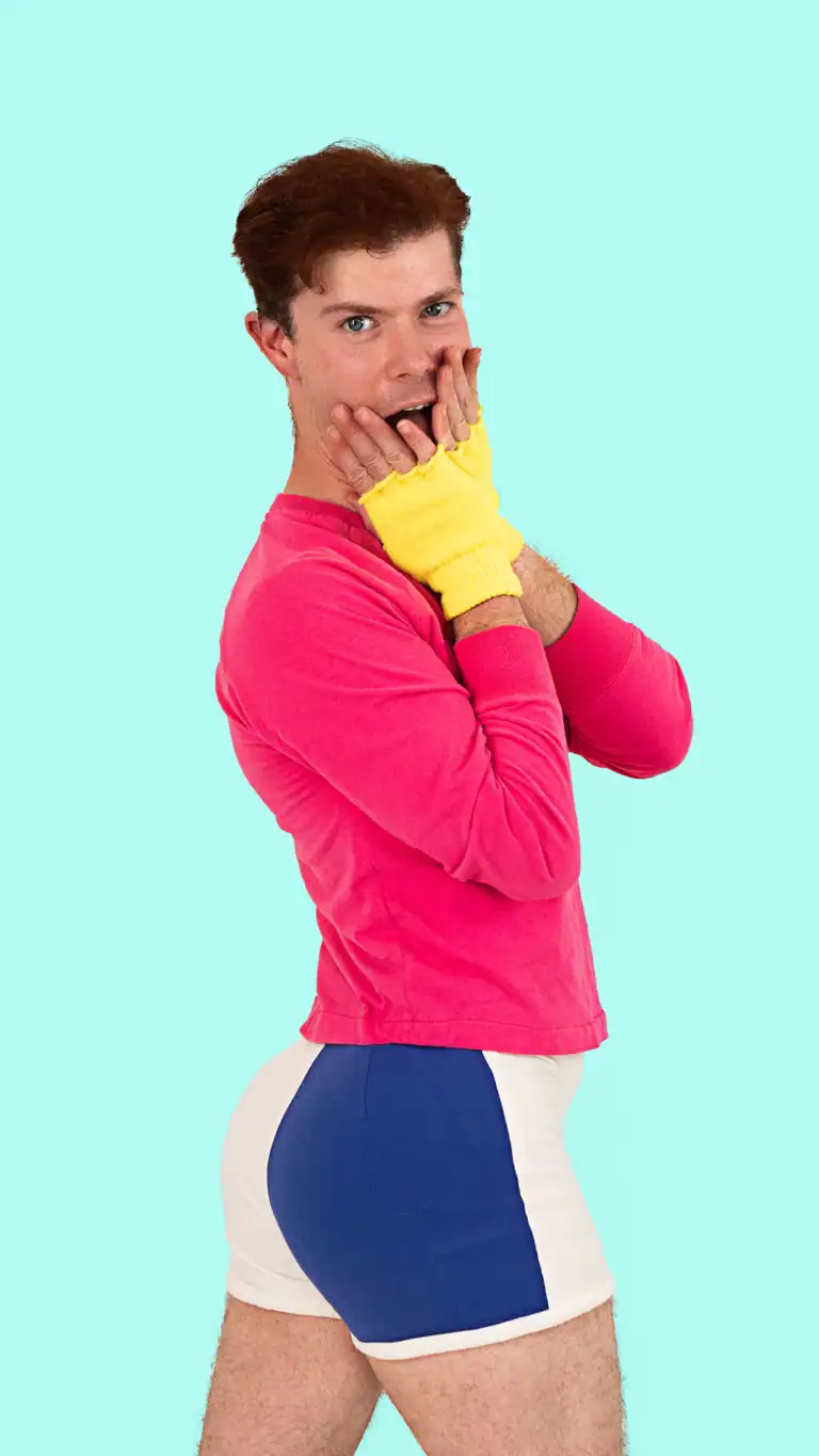 Designs Elijah's George Michael costume, pink shirt, yellow fingerless gloves, and short blue and white shorts.
